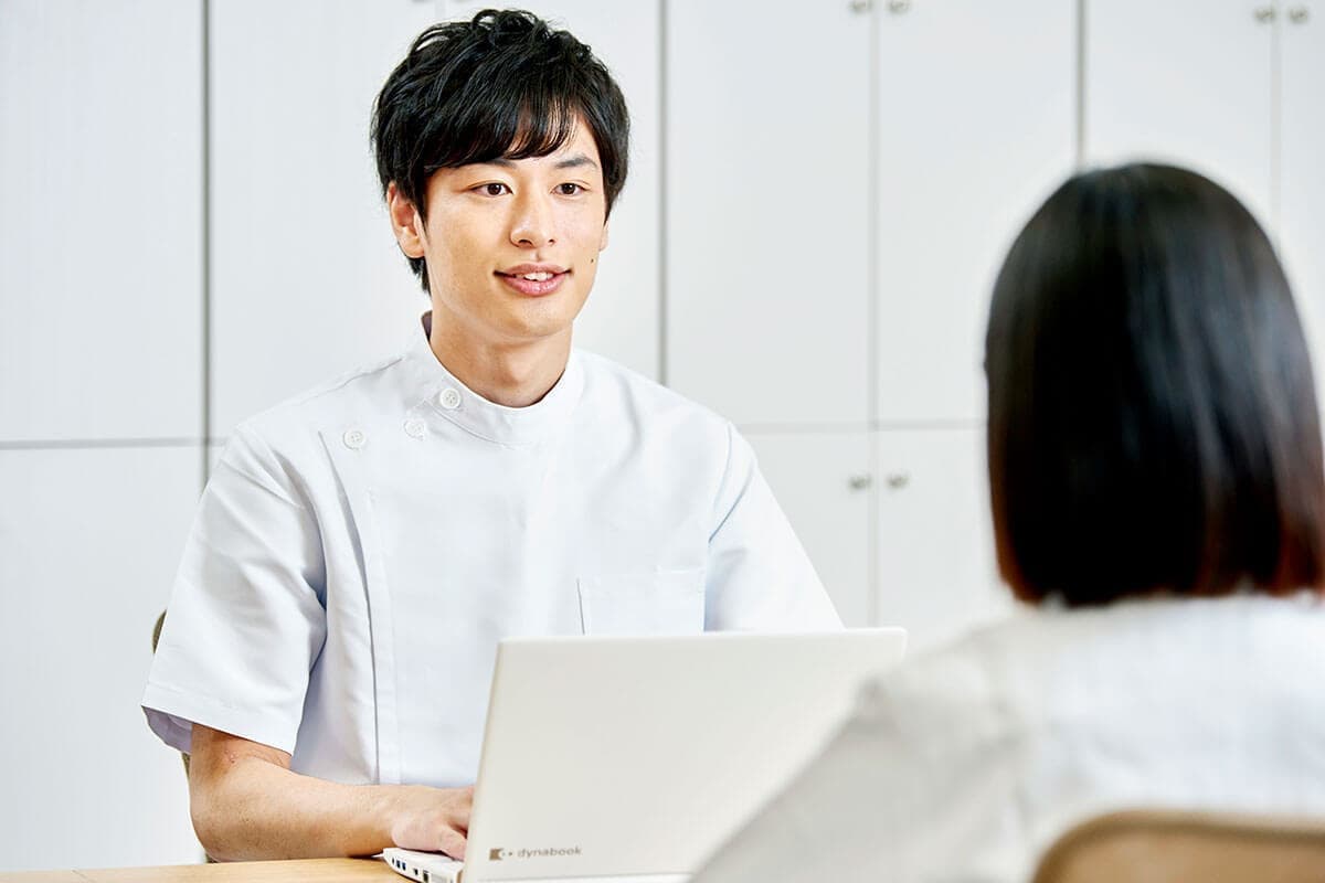 クリニックで打ち合わせをする男性看護師