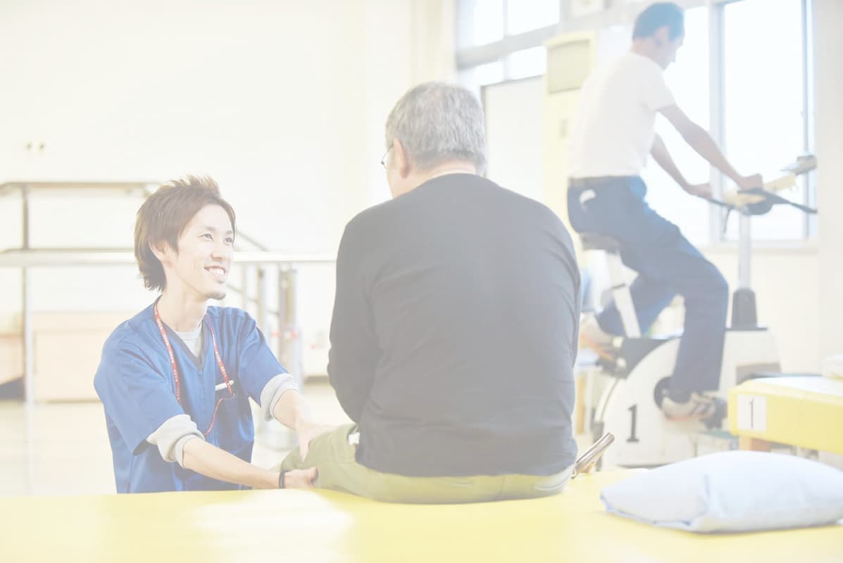 病院で患者に介護をする男性
