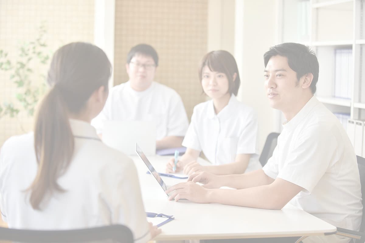 クリニックで打ち合わせをする男性看護師