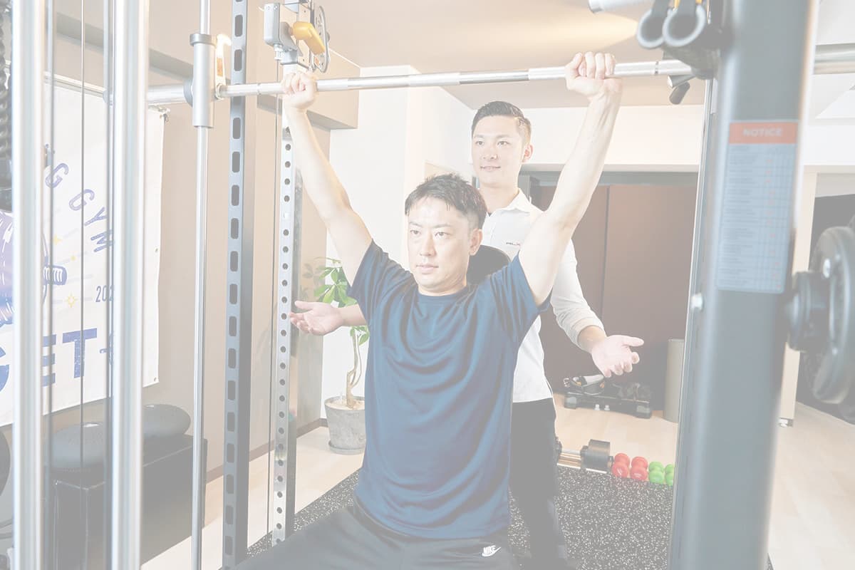 バーベルをあげる男性とトレーナー