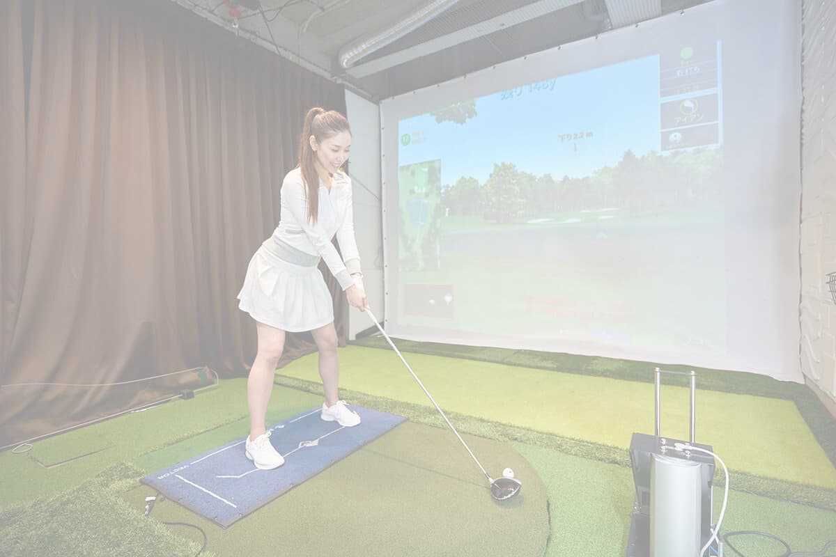 ゴルフスクールで練習する女性