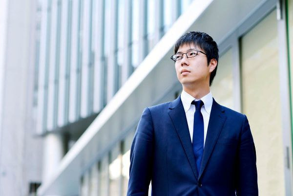 会社の前で立つ男性