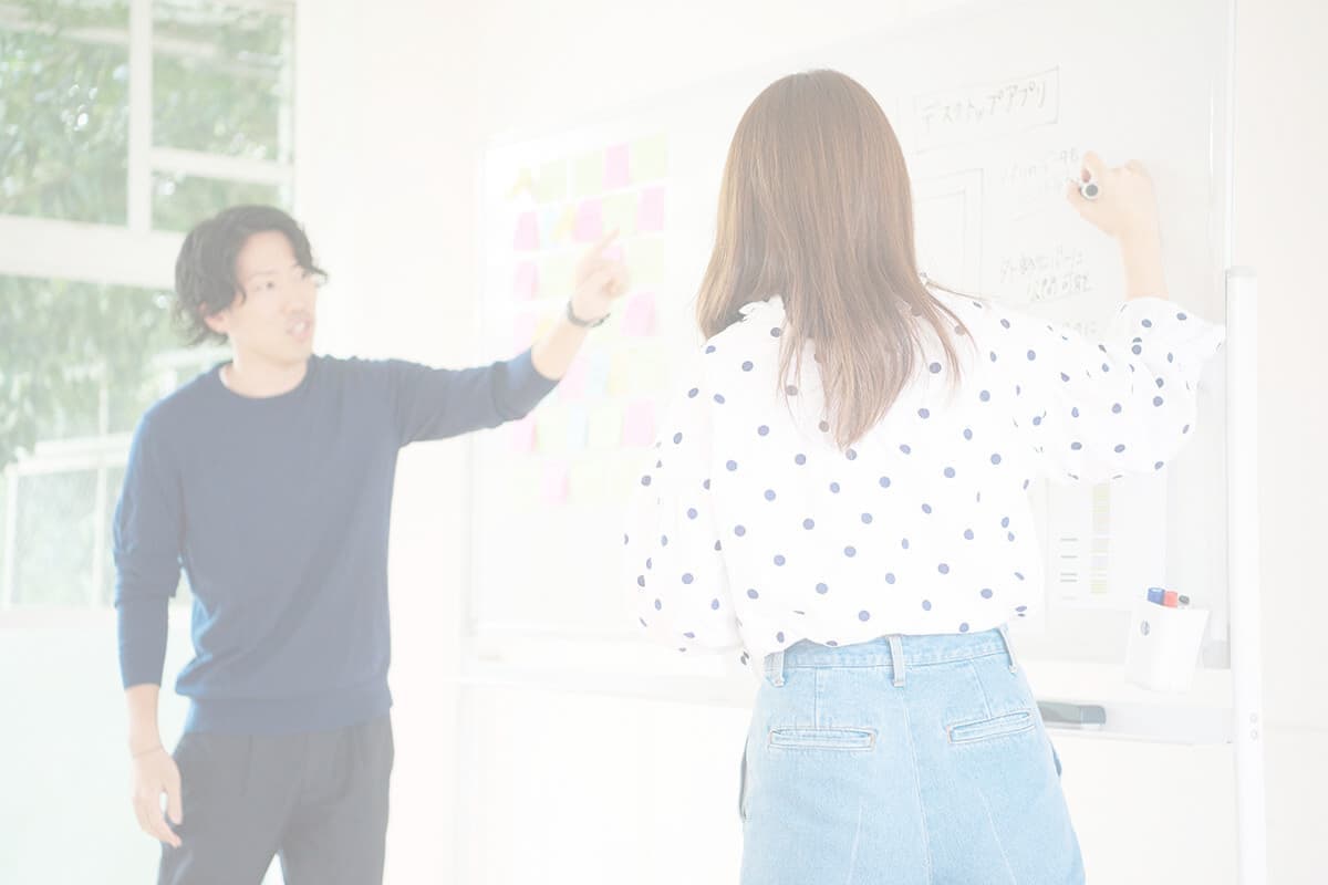 ホワイトボードに書き込む社員