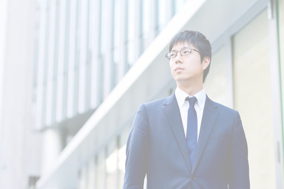 会社の前に立つ社員の写真