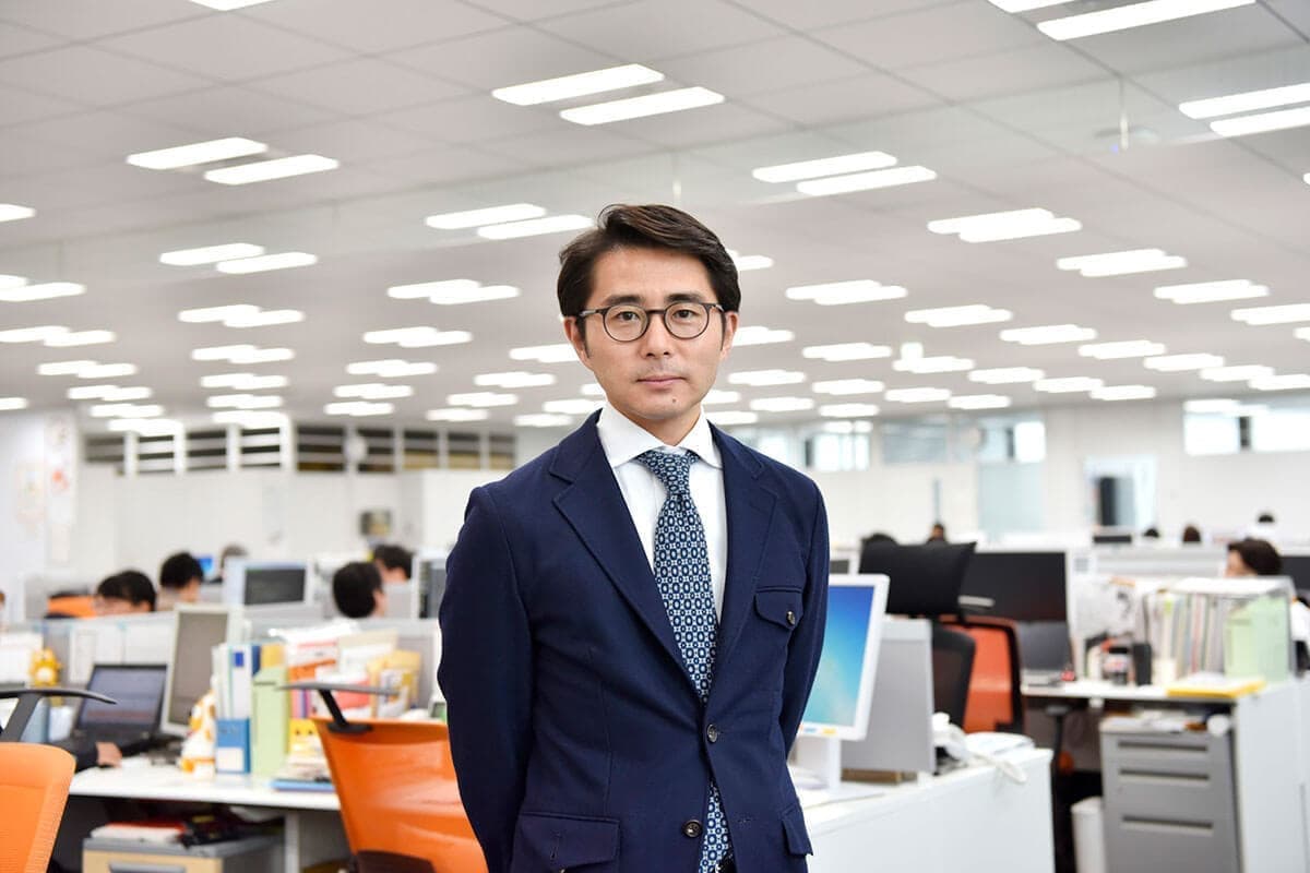 職場の前に立つ男性社員