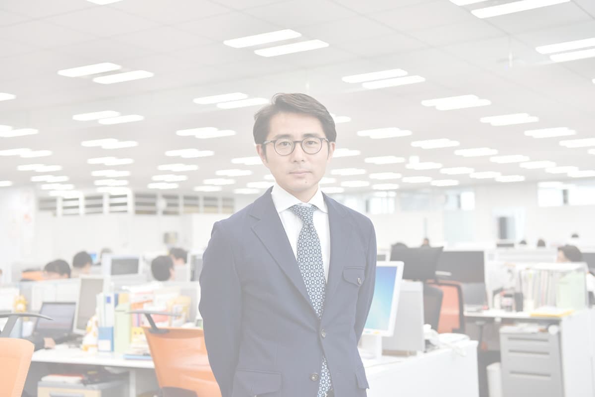 職場の前に立つ男性社員