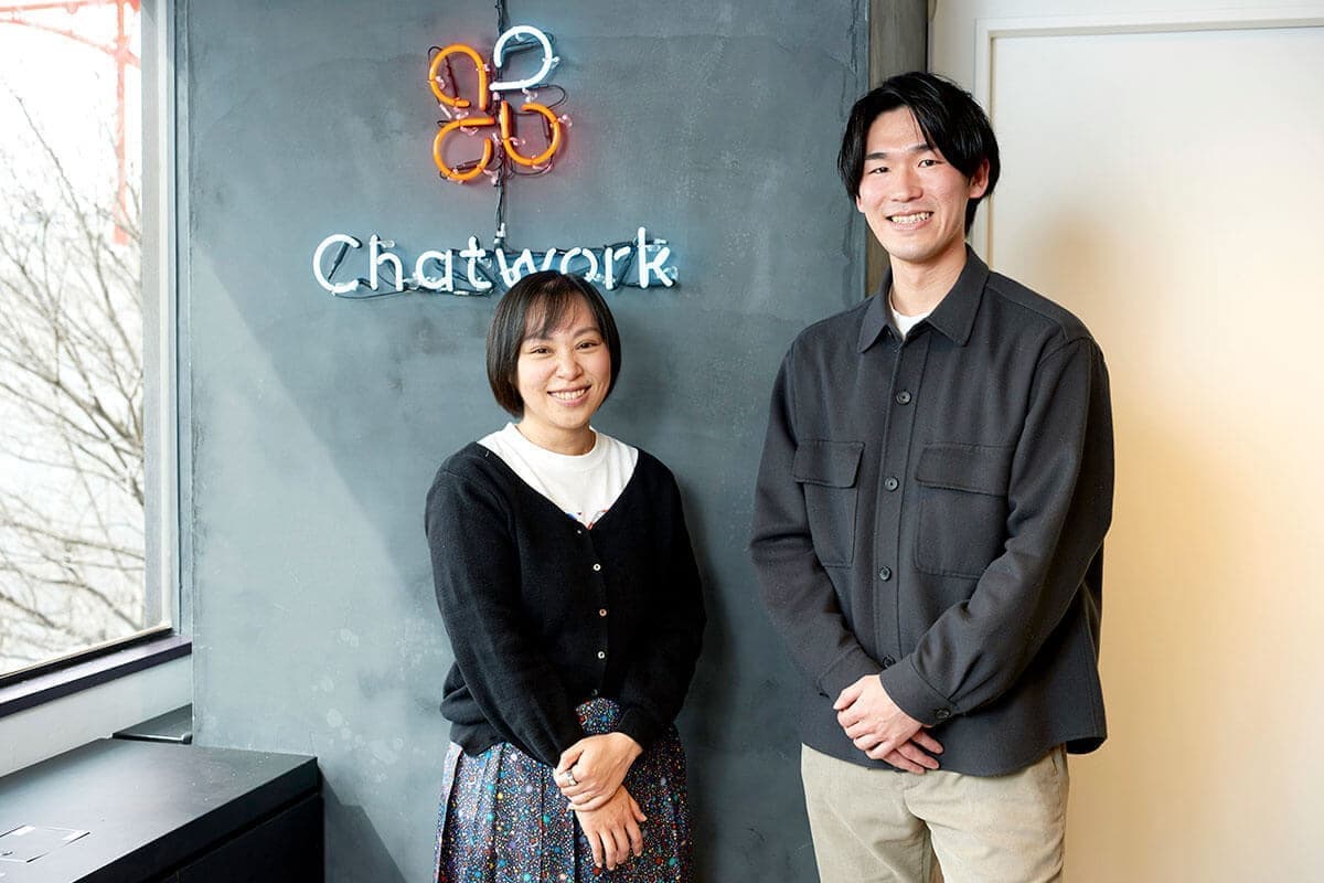 受付の前に立つ男性社員と女性社員