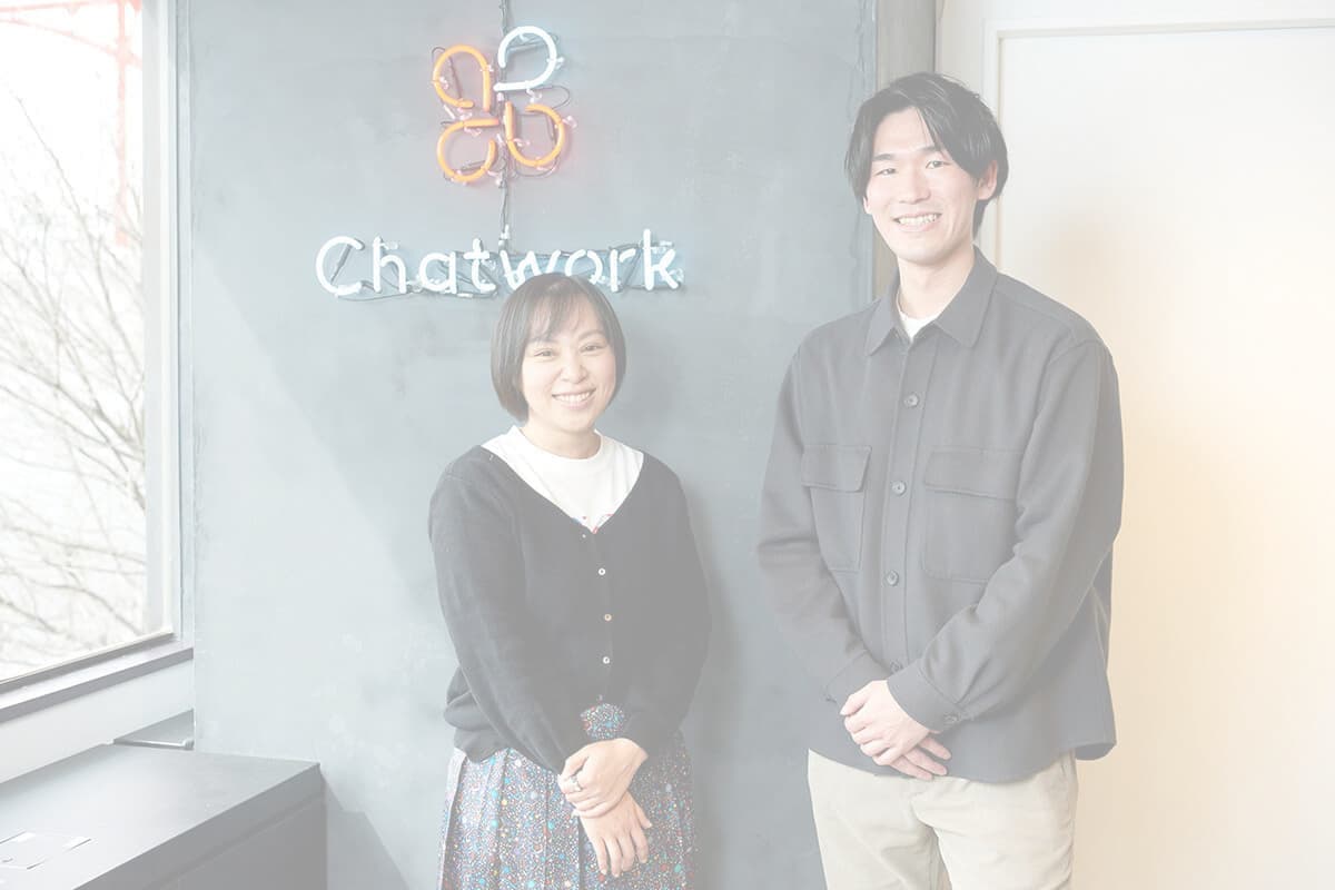 受付の前に立つ男性社員と女性社員