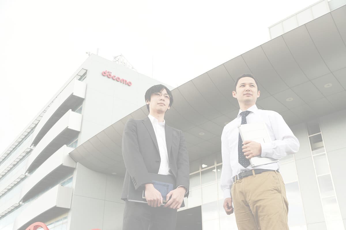 会社の前に立つ男性の写真