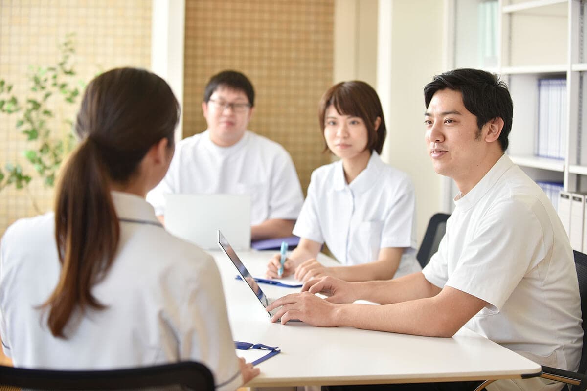 クリニックで打ち合わせをする男性看護師